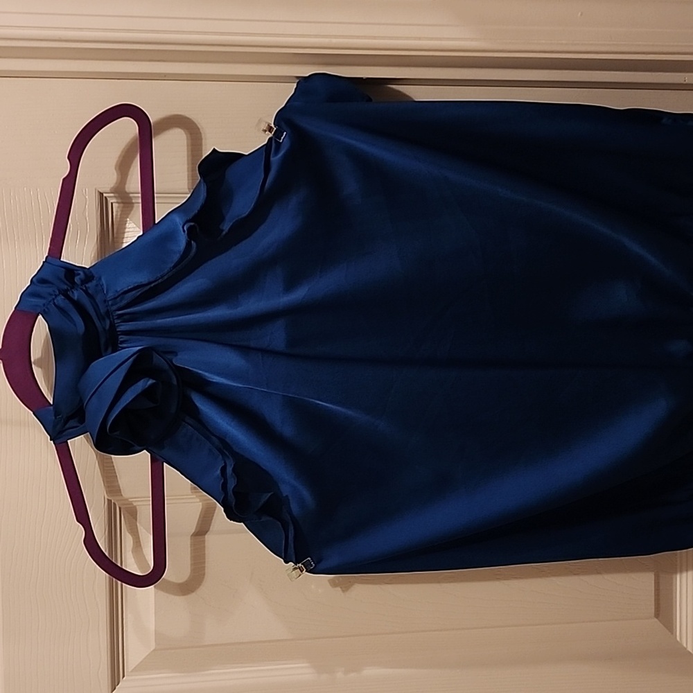 Dressy Satin Top with a flower and ruffle accents.